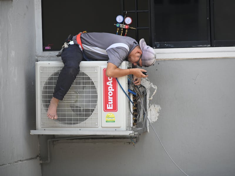 Certified technician installing wall-mounted air conditioning system