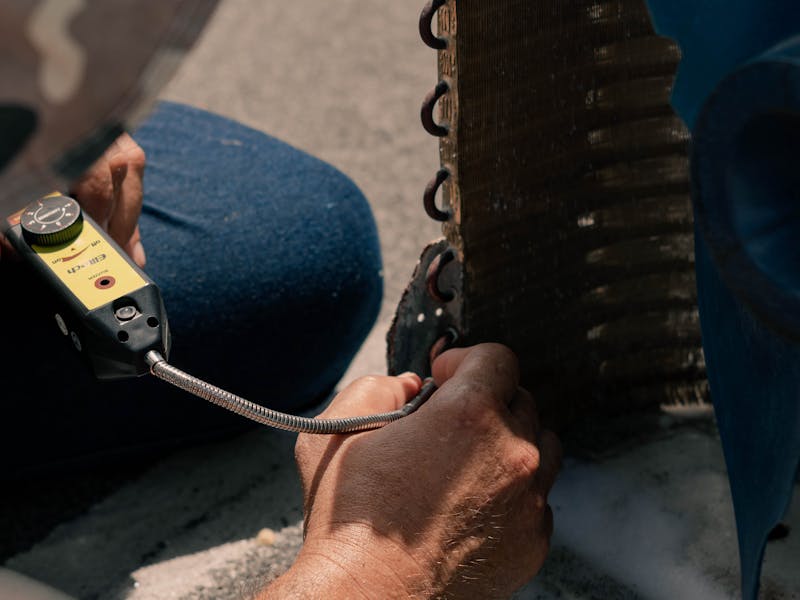 HVAC technician repairing an air conditioning unit with professional tools